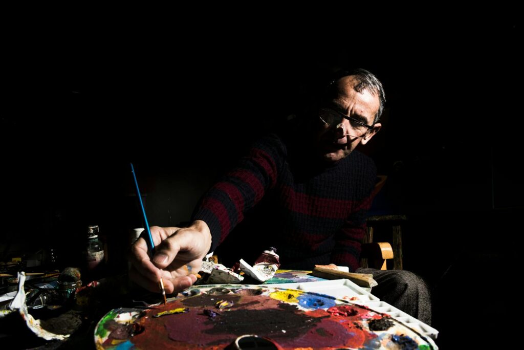 Artist sitting and painting in a studio
