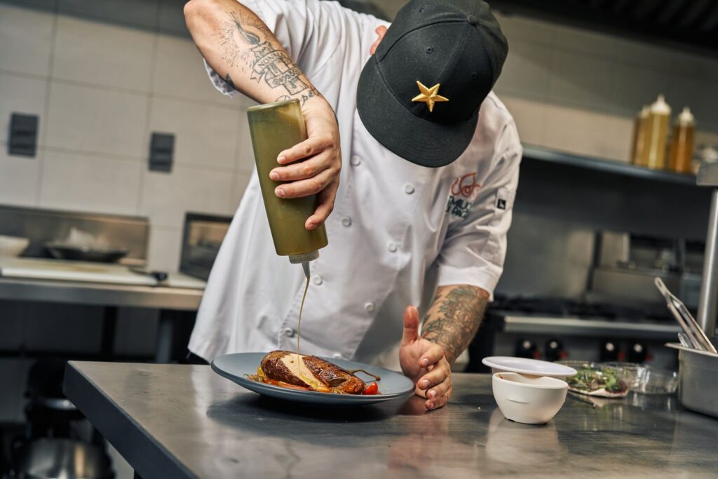Chef garnishing a dish in a professional kitchen